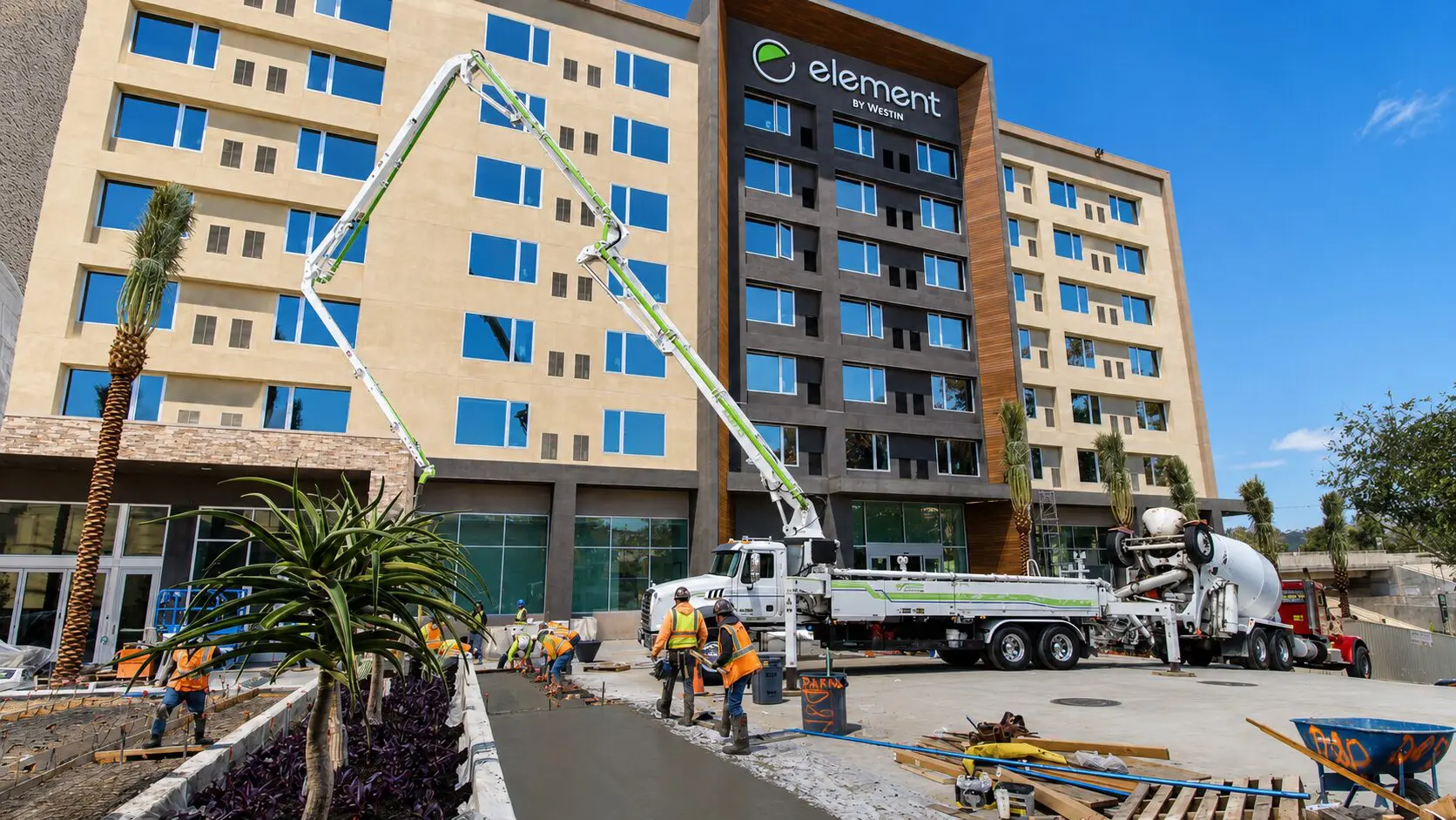 Workers laying concrete outside hotel