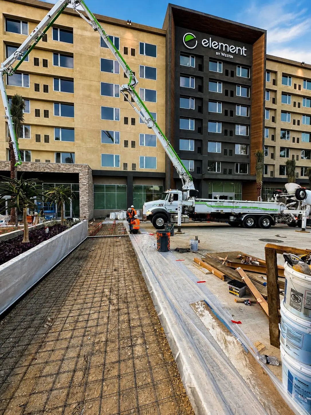 Workers paving area near hotel entrance