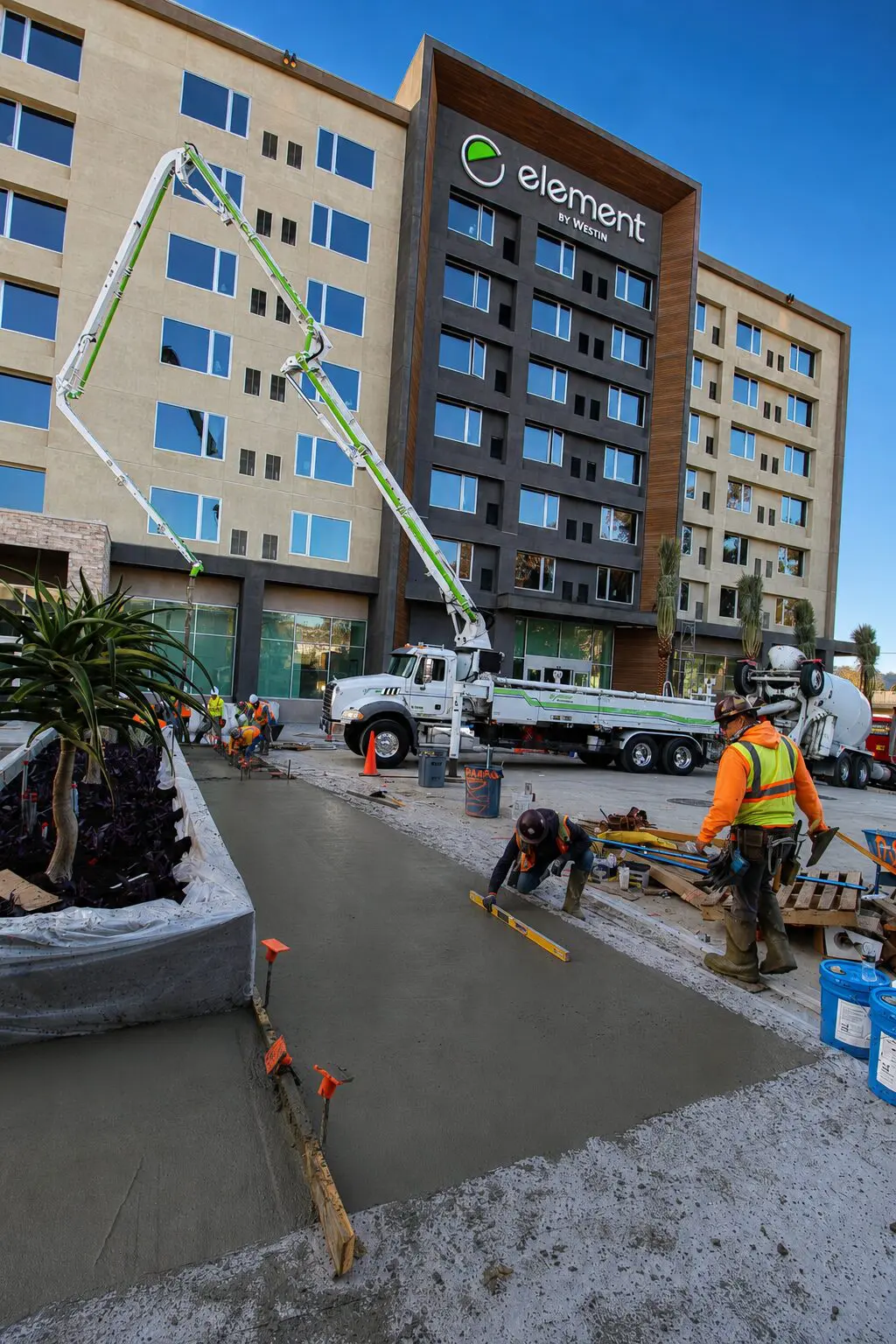 Construction workers pouring concrete outside building