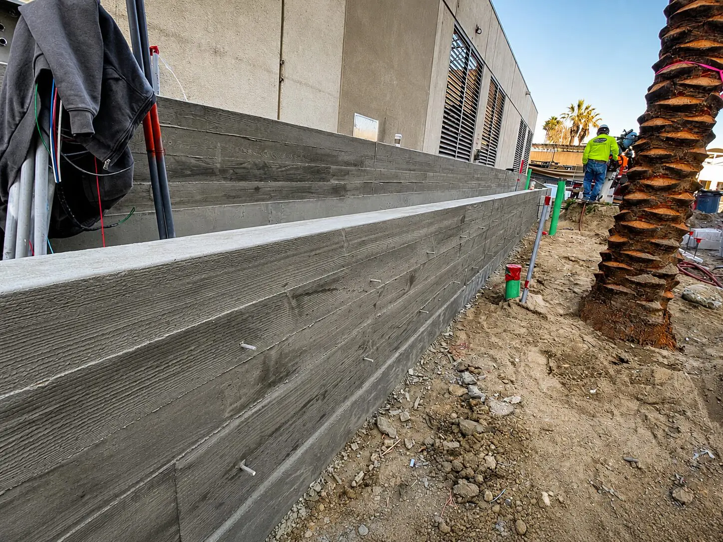 Construction site with concrete wall and palm tree