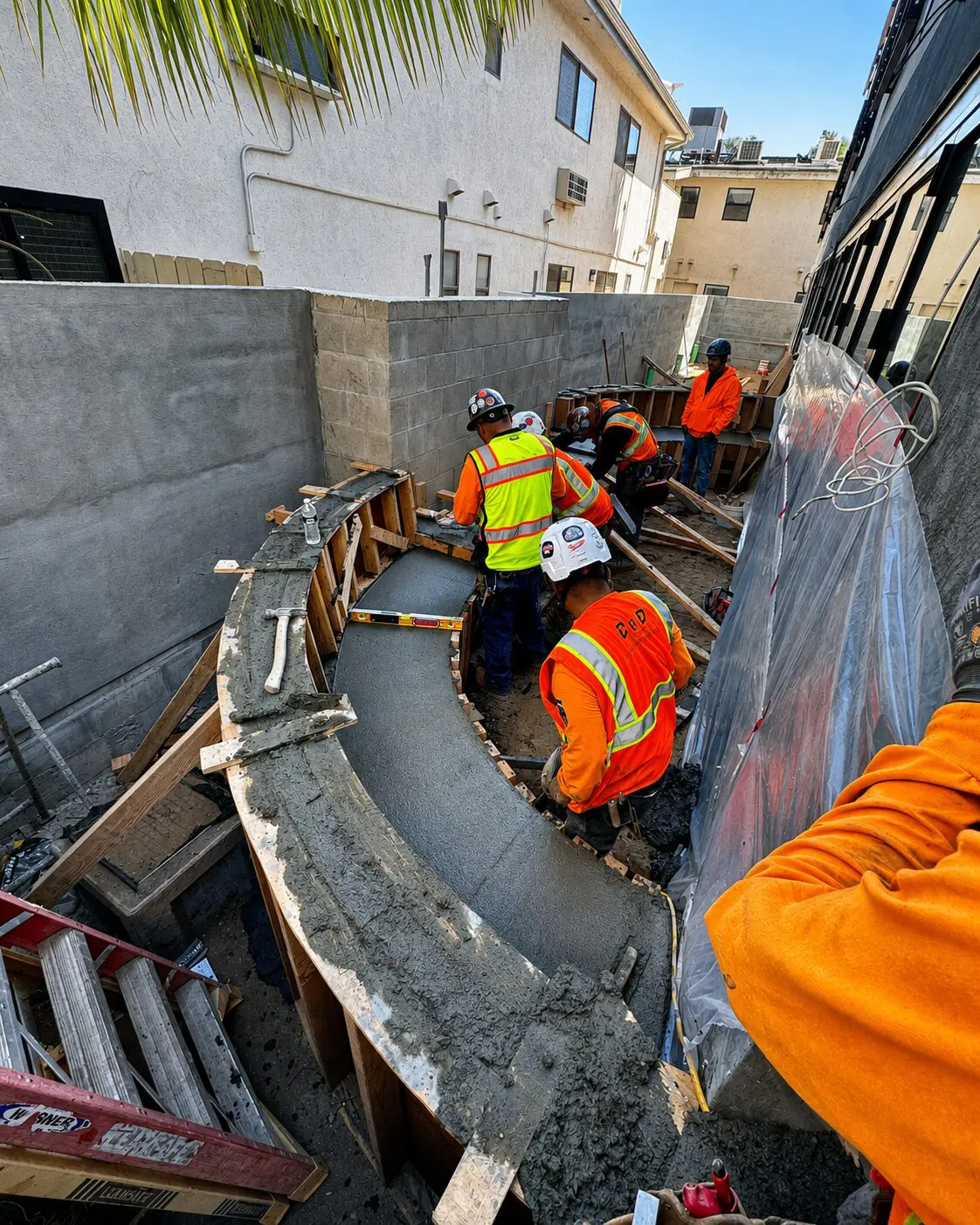Construction workers pouring concrete wall
