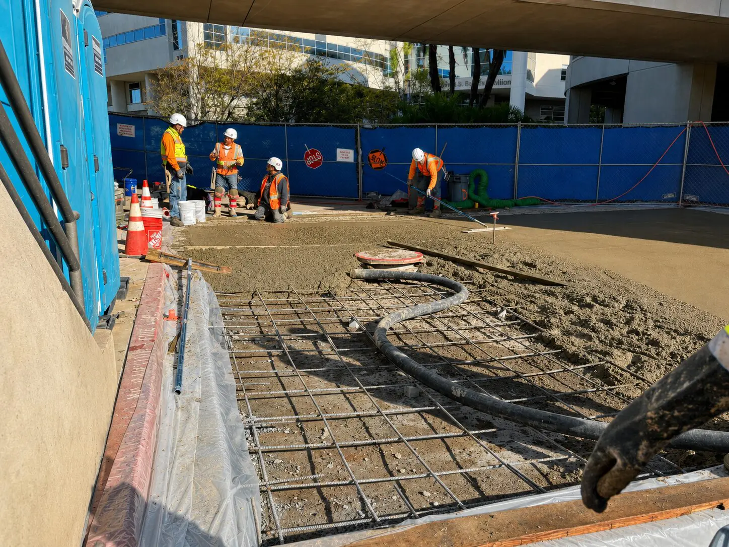 Cement being poured by construction workers