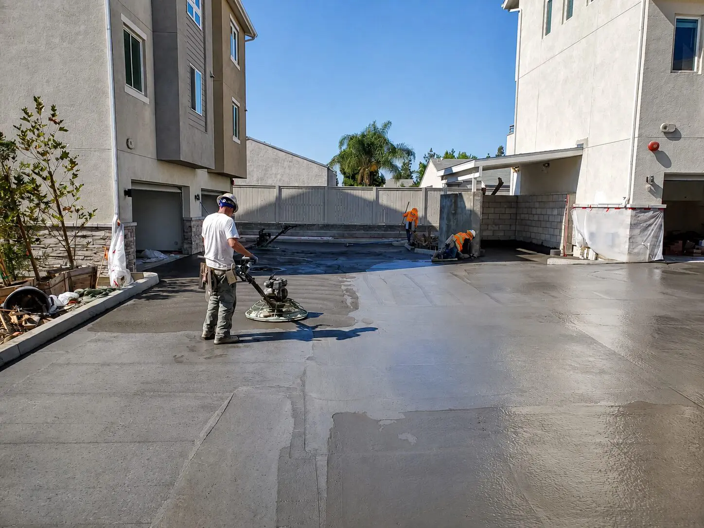 Workers leveling concrete in residential area