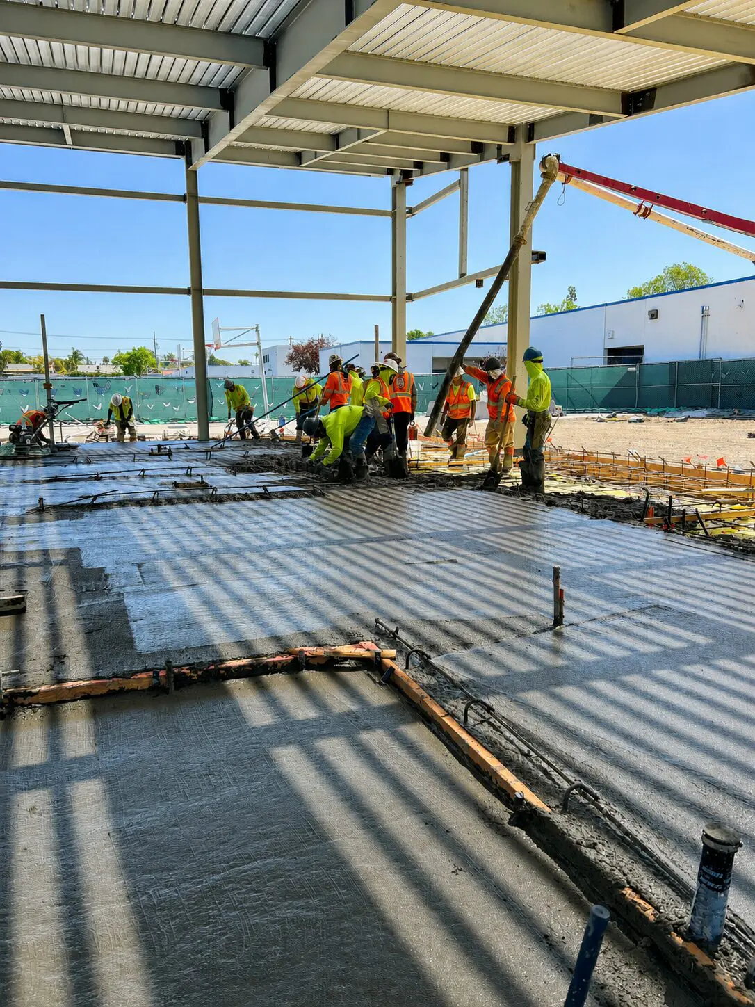 Team pouring concrete in building framework
