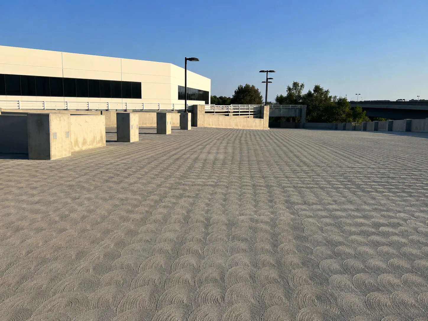 Empty rooftop parking area with blue sky.
