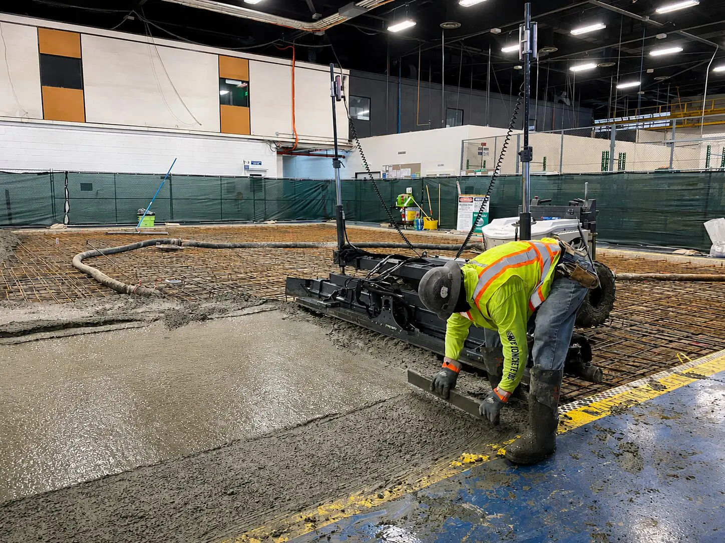 Worker using concrete leveling machine indoors