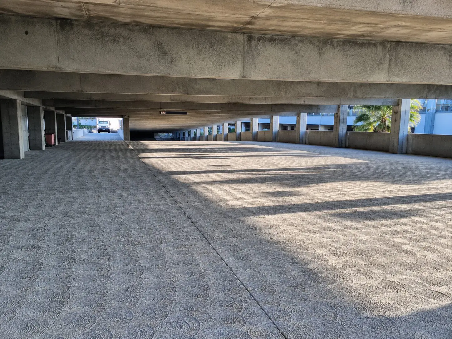 Concrete parking area with overhead beams