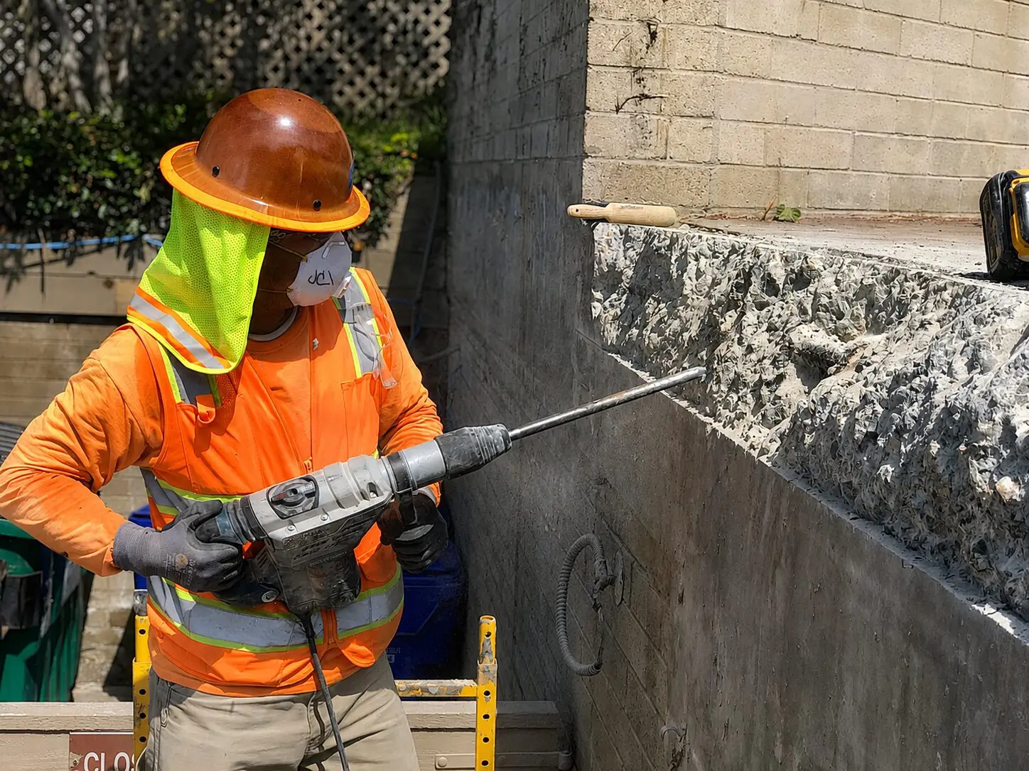 Safety-vested worker with drill tool