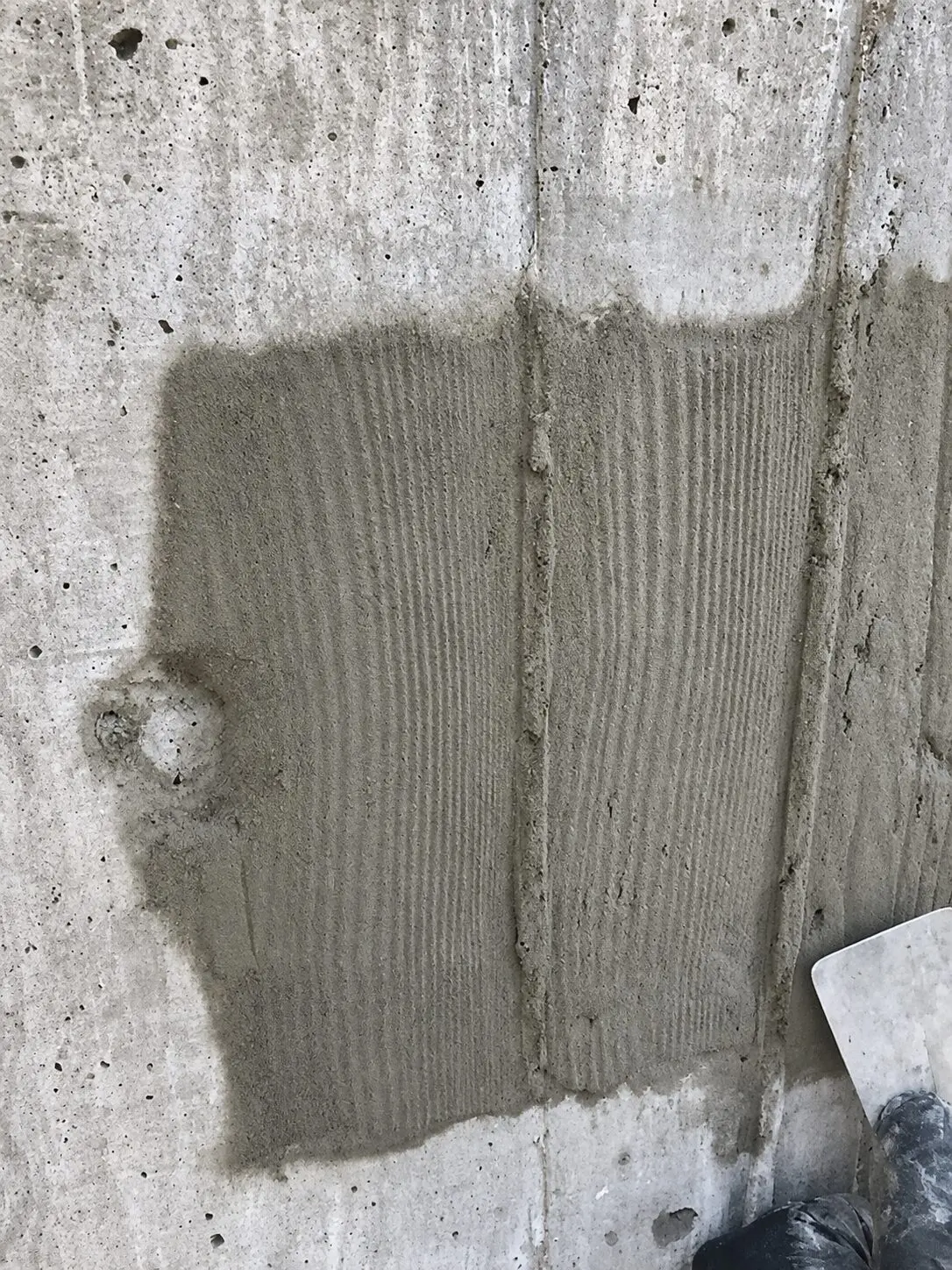 Fresh concrete patch on wall