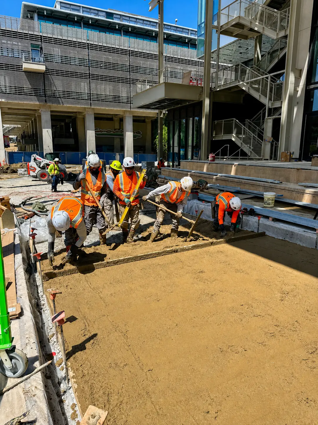 Team smoothing sandy construction site