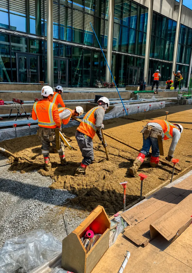 Construction workers laying gravel at site