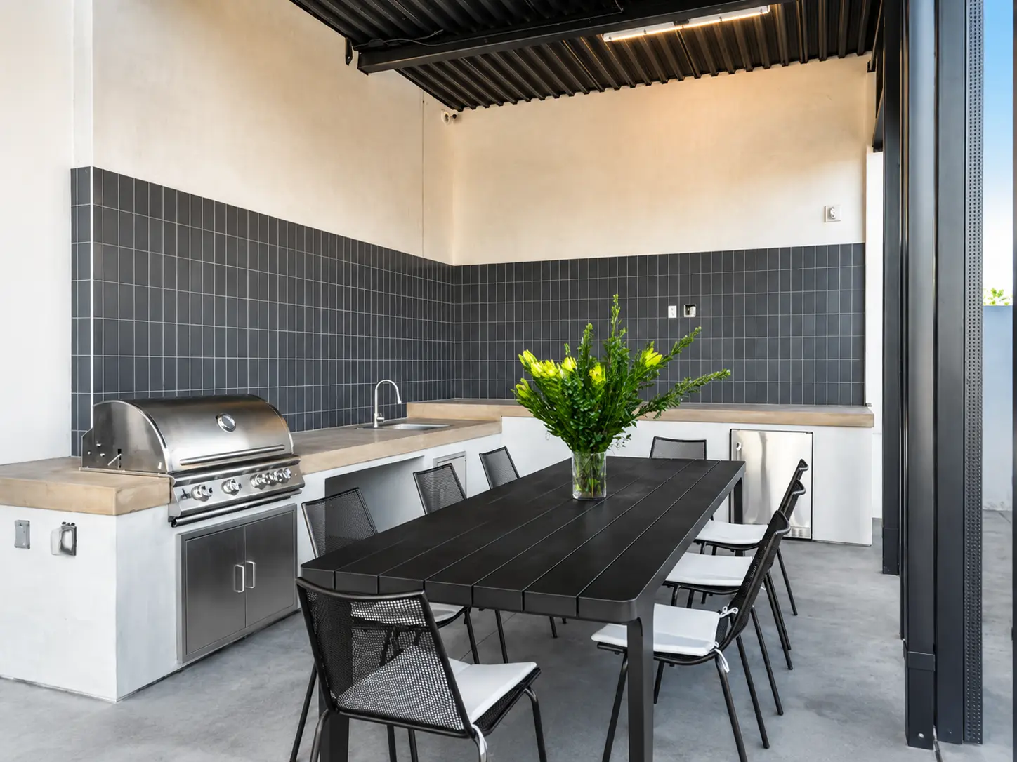 Outdoor kitchen with grill and dining table.